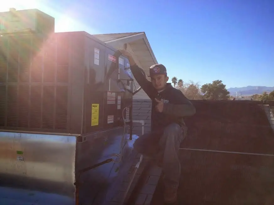 HVAC technician performing Air Duct Cleaning on a rooftop unit in Dyer